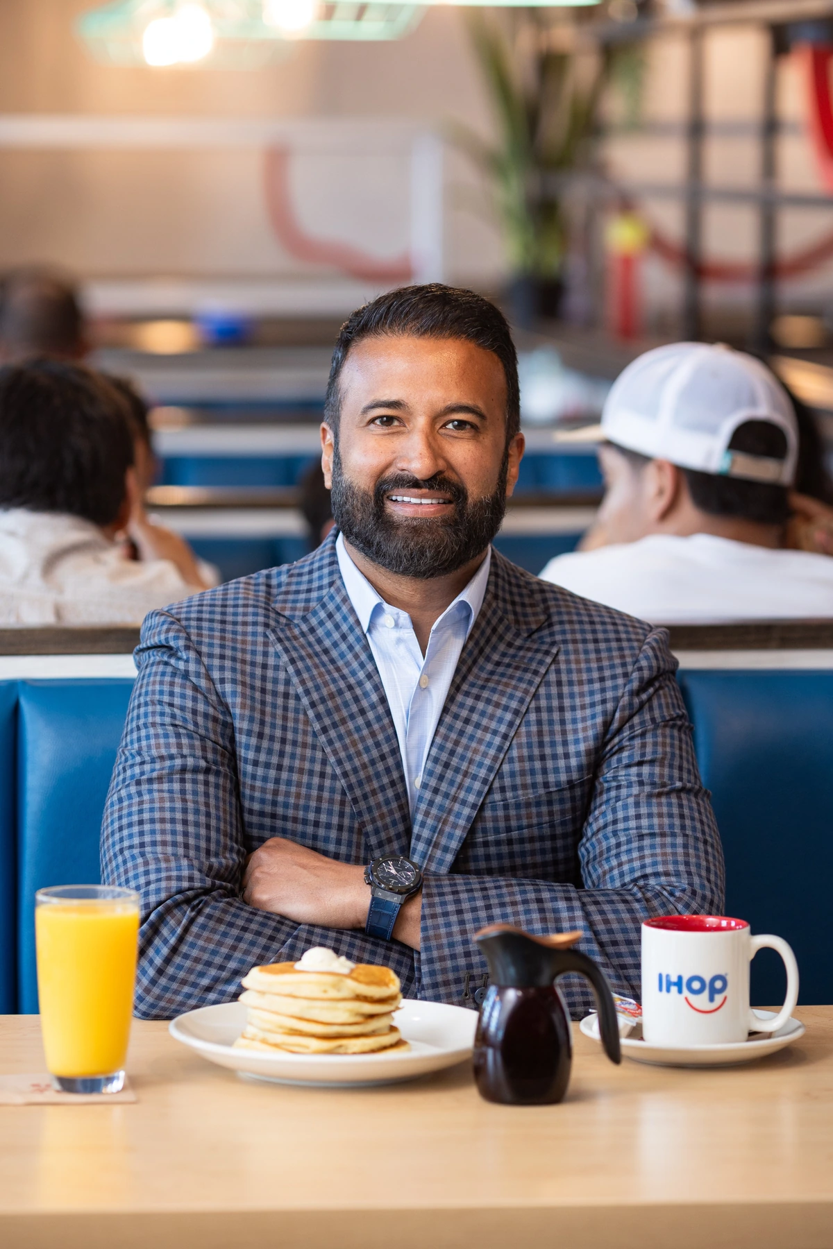 Alex Anthraper seated at an IHOP table with pancakes and coffee