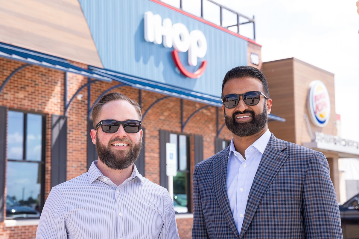 Jim McGarvey and Alex Anthraper standing together outside an IHOP restaurant