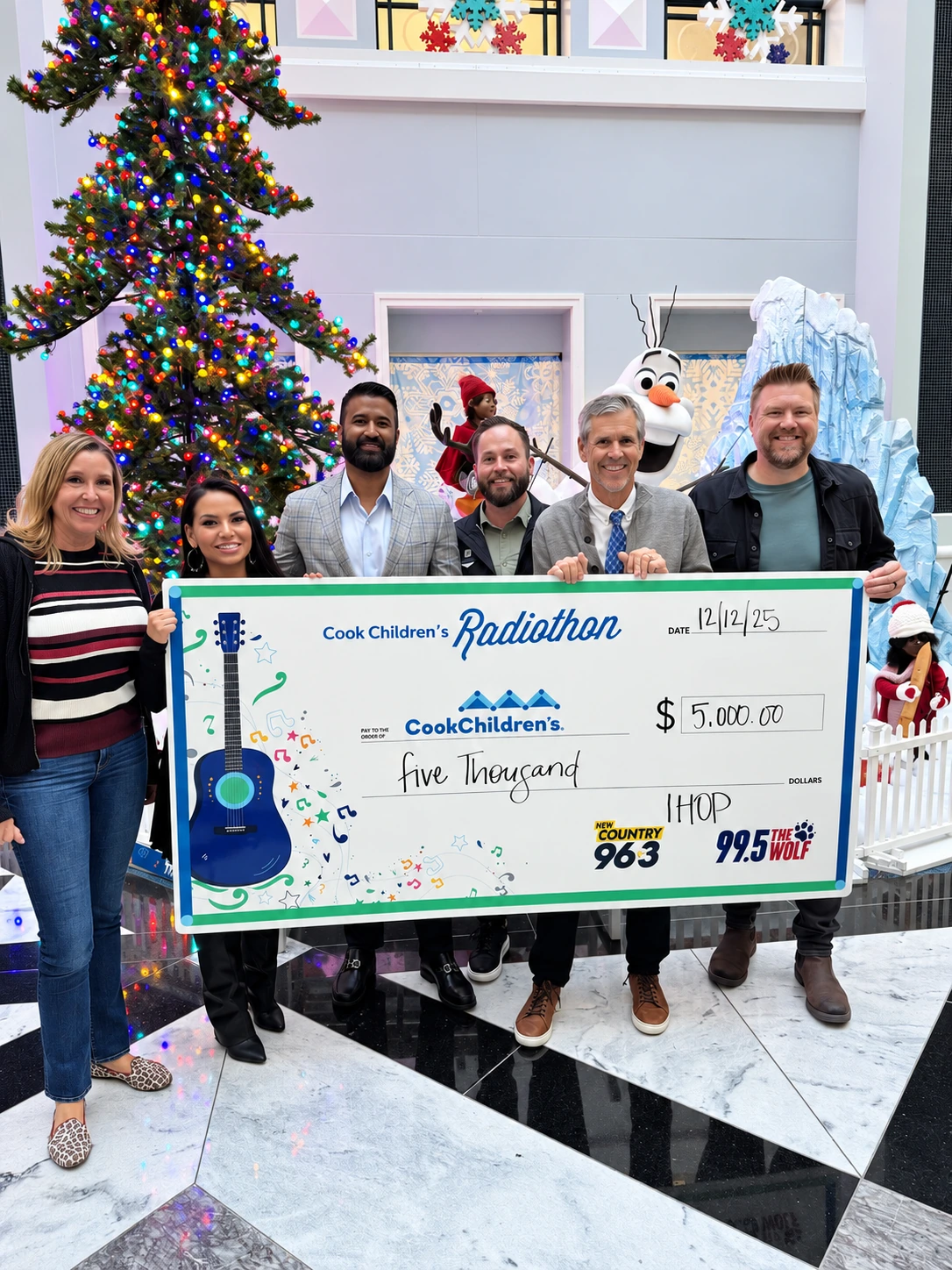 Anthraper Restaurants team members and Radiothon partners holding a $5,000 donation check for Cook Children’s