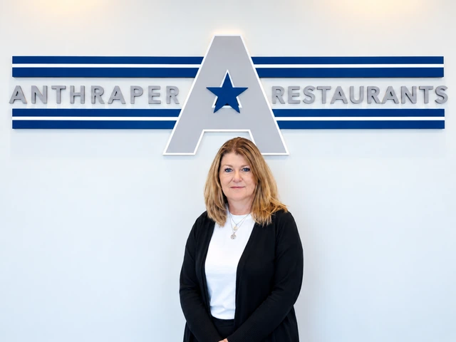 Kim Anthraper standing in front of the Anthraper Restaurants office sign