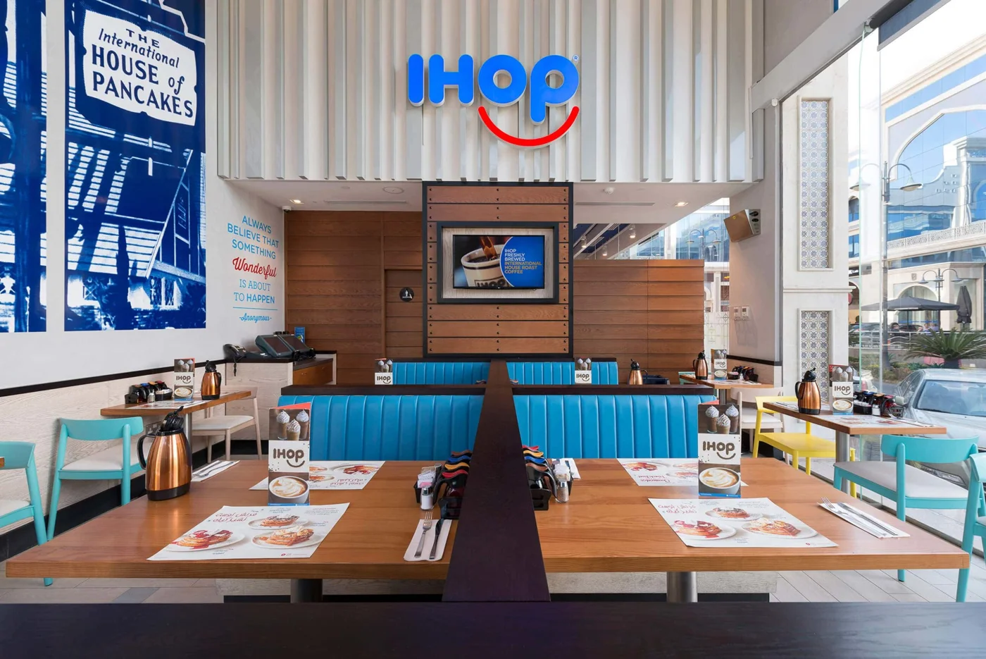 A bright IHOP dining room with blue booths and tables ready to welcome guests